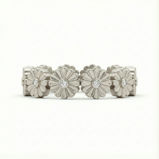 Silver floral ring with embedded stones on a white background
