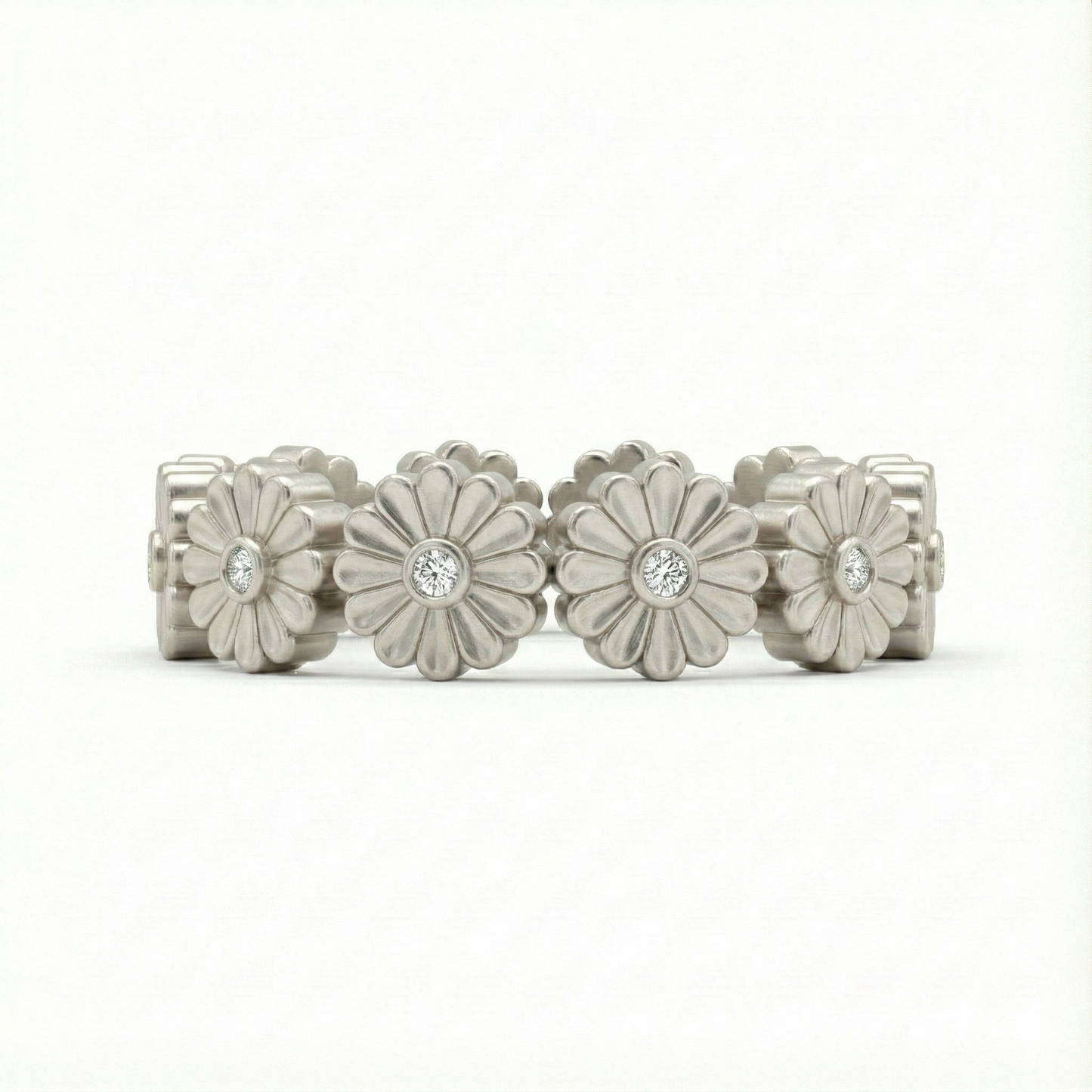 Silver floral ring with embedded stones on a white background