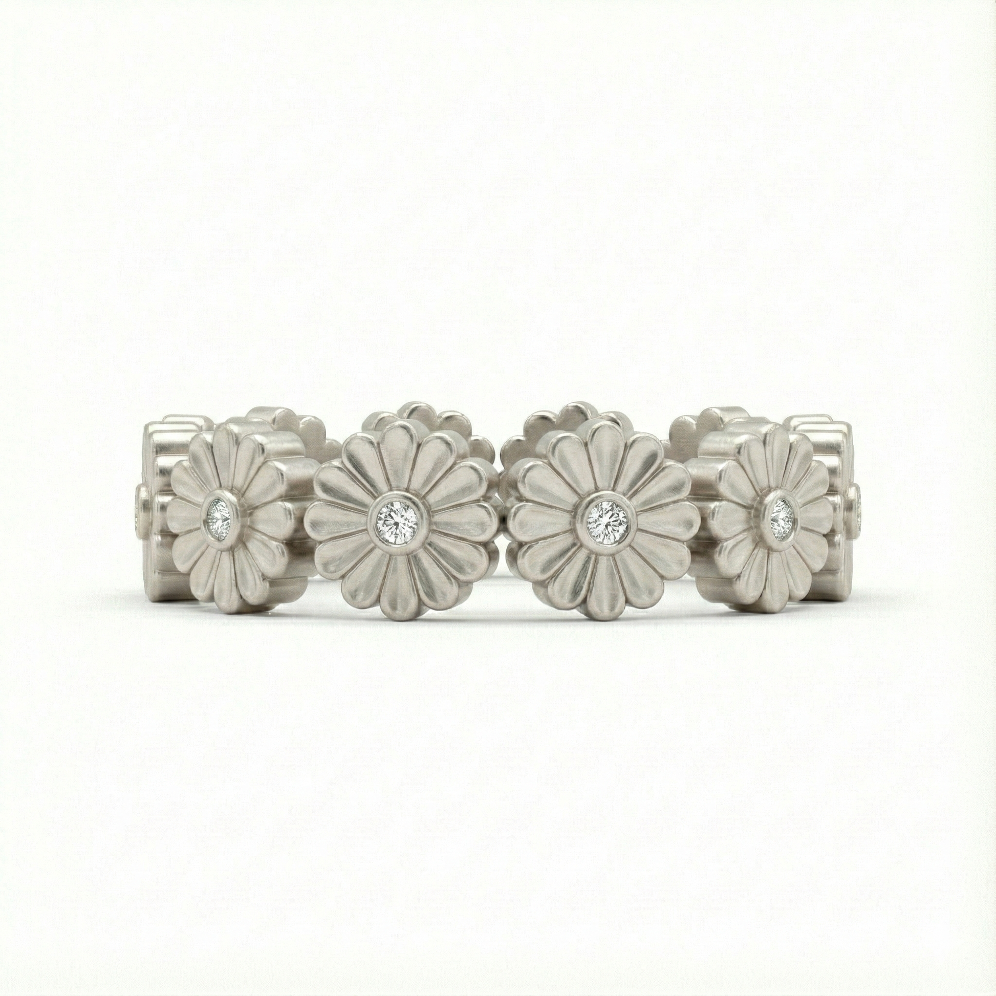 Silver floral ring with embedded stones on a white background
