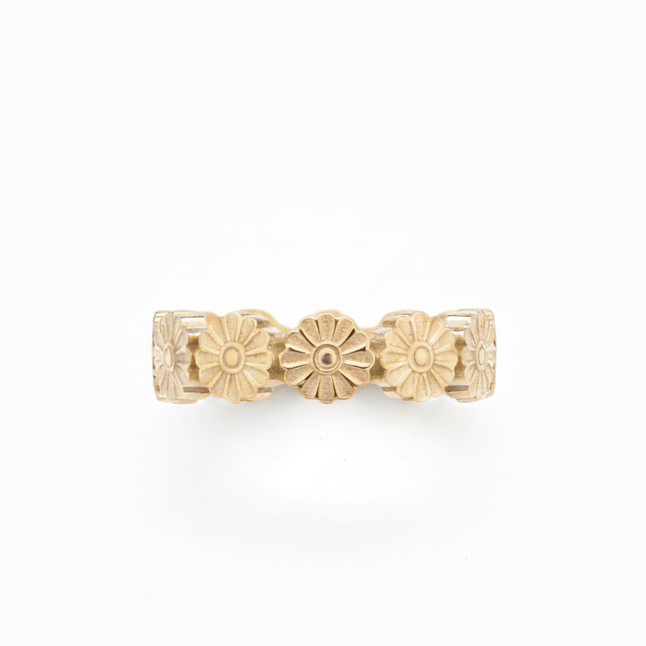 Gold ring with floral designs on a white background