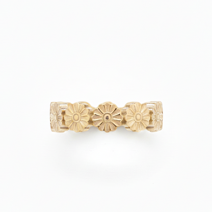 Gold ring with floral designs on a white background